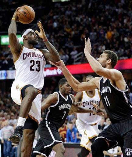 Cleveland Cavaliers' LeBron James (23) shoots toward the basket against Brooklyn Nets’ Brook Lopez (11) in the second half of an NBA basketball game Saturday, Nov. 28, 2015, in Cleveland. The Cavaliers won 90-88. (AP Photo/Tony Dejak)