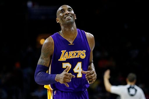 Los Angeles Lakers' Kobe Bryant smiles as he jogs to the bench during the first half of an NBA basketball game against the Philadelphia 76ers, Tuesday, Dec. 1, 2015, in Philadelphia. (AP Photo/Matt Slocum)