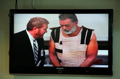 FILE - In this Nov. 30, 2015 file-pool photo, Colorado Springs shooting suspect, Robert Dear, right, appears via video before Judge Gilbert Martinez, with public defender Dan King, at the El Paso County Criminal Justice Center for this first court appearance, where he was told he faces first degree murder charges, in Colorado Springs, Colo. The man accused of killing three people at a Colorado Planned Parenthood clinic brought several guns, ammunition and propane tanks that he assembled around a car. To some in the community, the attack resembled an act of domestic terrorism, sparking a debate over what to call Robert Lewis Dear’s rampage even before he was taken into custody. (Daniel Owen/The Gazette via AP, Pool, File)