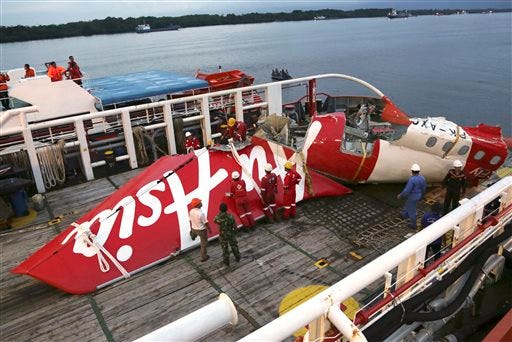 FILE - In this Sunday, Jan.11, 2015 file photo, crew members of Crest Onyx recovery ship prepare to unload the newly-recovered tail section of crashed AirAsia Flight 8501 at Kumai port in Pangkalan Bun, Central Borneo, Indonesia.  Indonesian investigators say a faulty rudder control system and the pilots' response led to the crash of the plane last year that killed all 162 people on board. The National Transportation Safety Committee announced Tuesday, Dec. 1, 2015, that an analysis of Flight 8501's data recorder showed that the Airbus A320 had problems with its rudder control system while flying between the Indonesian city of Surabaya and Singapore on Dec. 28. (AP Photo/Achmad Ibrahim, File)