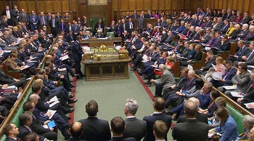 British Prime Minister David Cameron, standing centre left, talks to lawmakers inside the House of Commons in London during a debate on launching airstrikes against Islamic State extremists inside Syria, Wednesday, Dec. 2, 2015. The parliamentary vote is expected Wednesday evening.  Opposition Labour Party leader, Jeremy Corbyn, looks at papers sitting centre right opposite Cameron, who opposes any expansion of Britain's military role. (Parliamentary Recording Unit via AP Video) TV OUT - NO ARCHIVE
