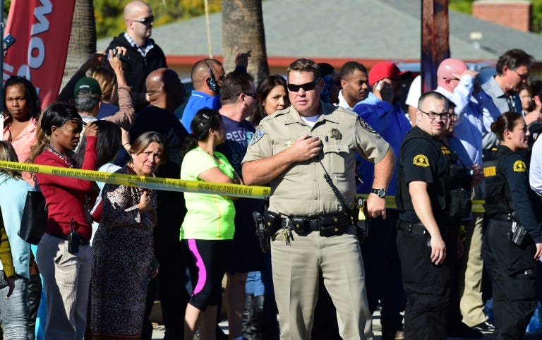 A crowd gathers behind police lines near the scene of a shooting on December 2, 2015 in San Bernardino, California
