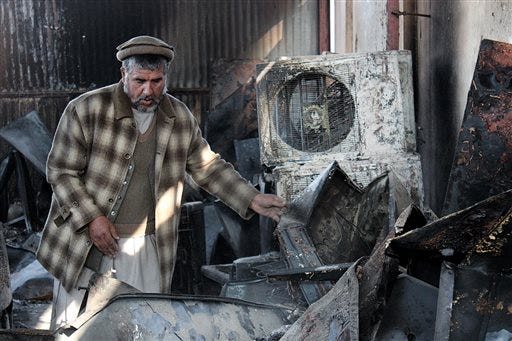 In this Tuesday, Dec. 1, 2015, photo, an Afghan business man salvages what he can from his warehouse that was destroyed from fighting in Kunduz city, north of Kabul, Afghanistan. Two months after the Taliban rampaged through the northern Afghan city of Kunduz, residents are still sifting through the rubble, wondering how they will ever rebuild and worrying that the insurgents will return. (AP Photo/Najim Rahim)