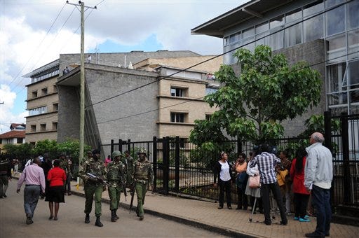 In this photo of Monday, Nov. 30, 2015. police patrol  after gunshots were heard at Strathmore University in Nairobi, Kenya,  Monday morning.  A drill to test terrorism preparedness at a leading Kenyan university led to a stampede in which one person died and 20 others were injured, the institution said Monday. Strathmore University said in a statement that one staff member had died as a result of injuries received during the drill aimed at testing the preparedness of the university community and emergency response team in the event of an attack..(AP Photo/John Muchucha)