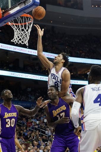 Philadelphia 76ers' Jahlil Okafor (8) goes over Los Angeles Lakers' Roy Hibbert (17) for a shot during the second half of an NBA basketball game, Tuesday, Dec. 1, 2015, in Philadelphia. Philadelphia won 103-91. (AP Photo/Matt Slocum)