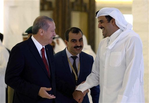 Turkey's President Recep Tayyip Erdogan, left, and Qatar's Emir Tamim bin Hamad Al Thani speak during a ceremony in Doha, Qatar, Wednesday, Dec. 2, 2015. Erdogan is on a two-day state visit to the Gulf emirate.(AP Photo/Yasin Bulbul, Presidential Press Service, Pool)