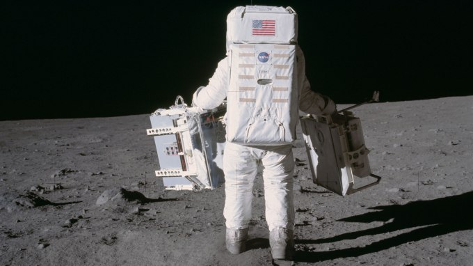 Astronaut and lunar module pilot Buzz Aldrin moves toward a position to deploy two components of the Early Apollo Scientific Experiments Package (EASEP) on the surface of the moon during the Apollo 11 extravehicular activity. The Passive Seismic Experiments Package (PSEP) is in his left hand; and in his right hand is the Laser Ranging Retro-Reflector (LR3). Mission commander Neil Armstrong took this photograph with a 70mm lunar surface camera. Image Credit: NASA