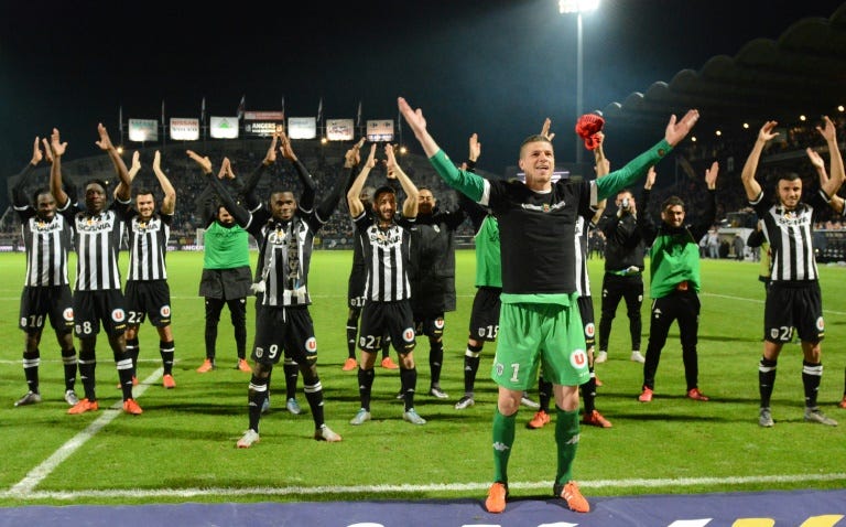 Angers' goalkeeper Ludovic Butelle (R) and his teammates cheer the crowd after holding Paris Saint-Germain to a 0-0 draw on December 1, 2015, at the Jean Bouin stadium