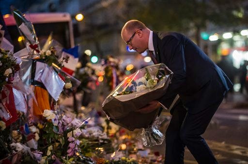 Czech Republic Prime Minister Bohuslav Sobotka pays his respects to victims of the Paris attacks in front of the Bataclan concert hall, in Paris, Monday, Nov. 30, 2015. The country remains on high alert for possible terrorist attacks after Islamic extremists killed at least 130 people in a rock concert massacre, shootings at Paris cafes and suicide bombings at the national stadium on Nov. 13. (AP Photo/Kamil Zihnioglu)