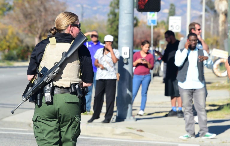 A heavily armed officer sets up a perimeter near the site of a shooting that took place on December 2, 2015 in San Bernardino, California