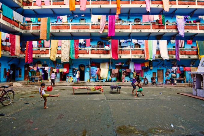 India, West Bengal, Kolkata, Calcutta, building courtyard, boy playing football